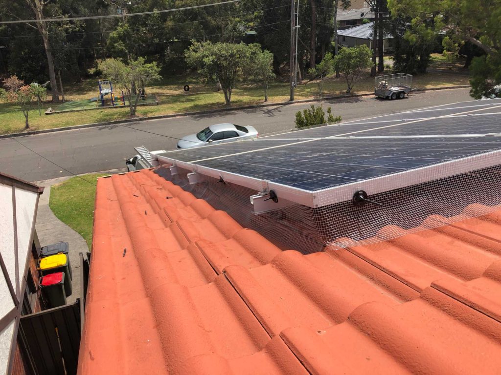 Mesh solar panel bird proofing on the terracotta-tiled roof of a Wollongong home
